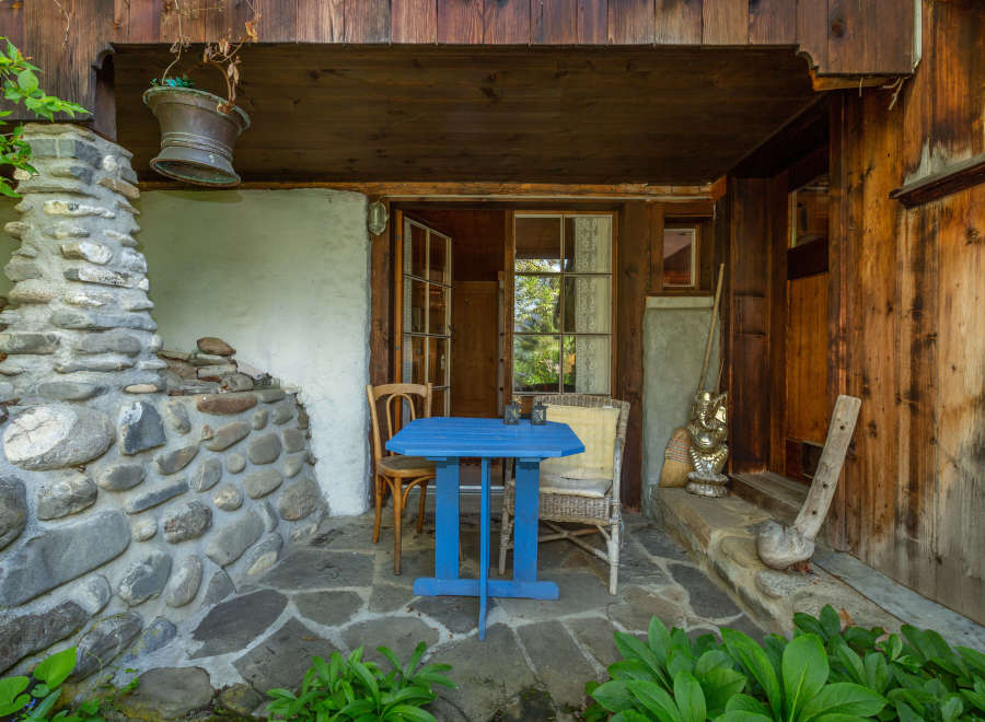 Discover the charm of this rustic retreat, featuring a cozy outdoor seating area perfect for relaxation.