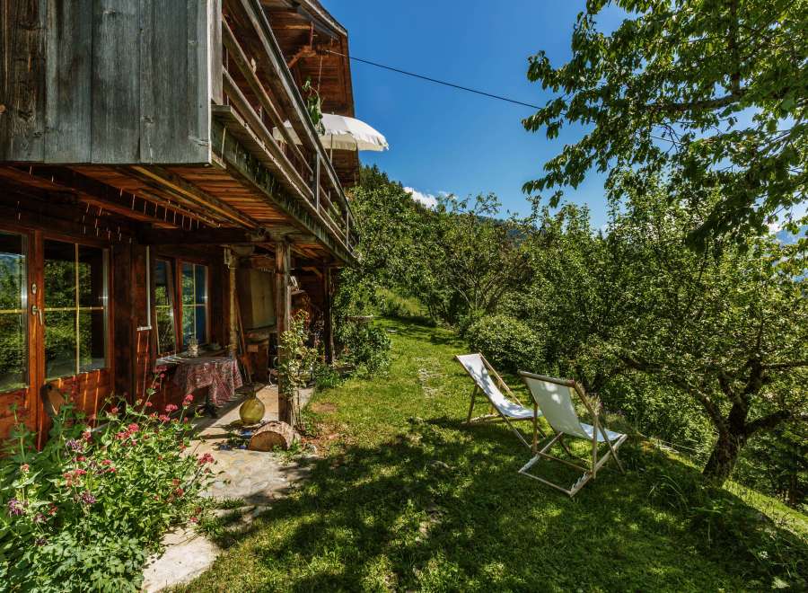 Escape to a charming wooden cabin nestled in a lush green landscape.