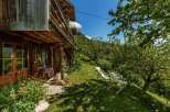 Escape to a charming wooden cabin nestled in a lush green landscape.