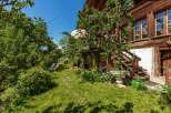 Discover the charm of this beautiful wooden house nestled in a lush green garden.
