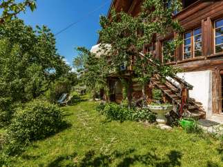Discover the charm of this beautiful wooden house nestled in a lush green garden.
