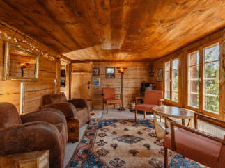 Step into a cozy cabin retreat with warm wooden interiors and inviting seating areas.