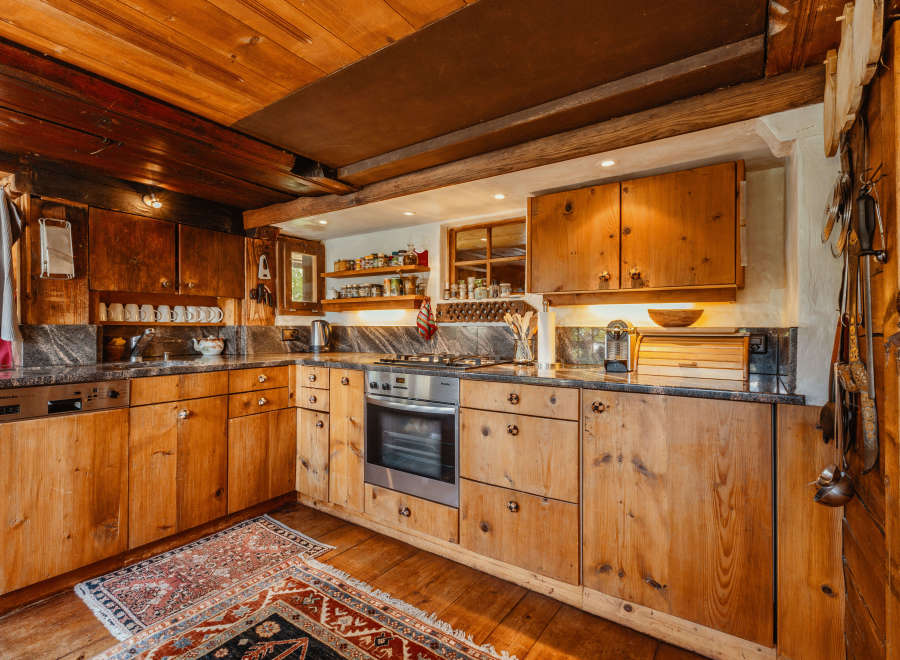 Step into a rustic kitchen with warm wooden cabinetry and a charming, traditional aesthetic.