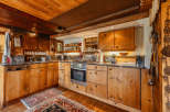 Step into a rustic kitchen with warm wooden cabinetry and a charming, traditional aesthetic.