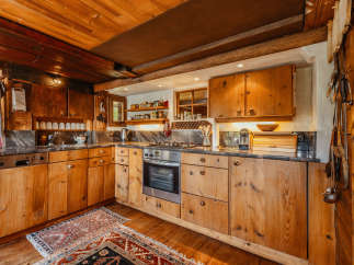 Step into a rustic kitchen with warm wooden cabinetry and a charming, traditional aesthetic.