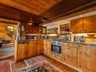 This rustic kitchen boasts beautiful wooden cabinetry and a warm, inviting atmosphere.