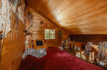 Cozy attic bedroom with wooden walls and ceiling.