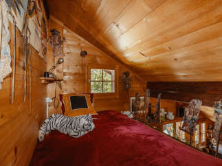 Cozy attic bedroom with wooden walls and ceiling.