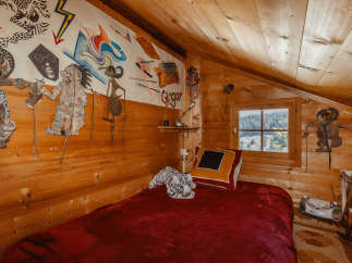 Cozy cabin bedroom with wooden walls and a charming, rustic aesthetic.