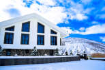 This stunning modern home boasts a sleek white exterior and unique window designs.