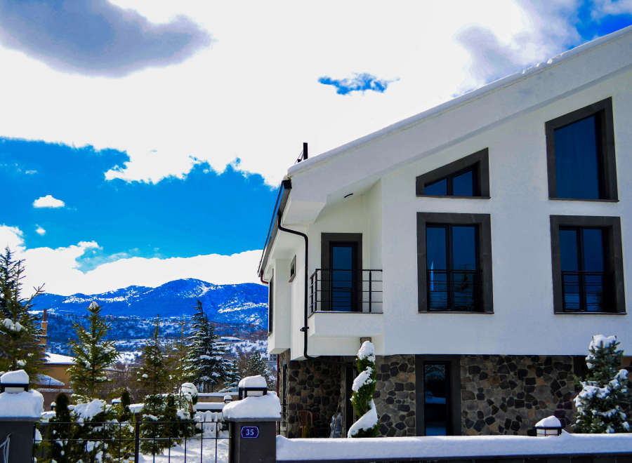 This stunning modern home boasts a sleek white exterior and unique architectural details.
