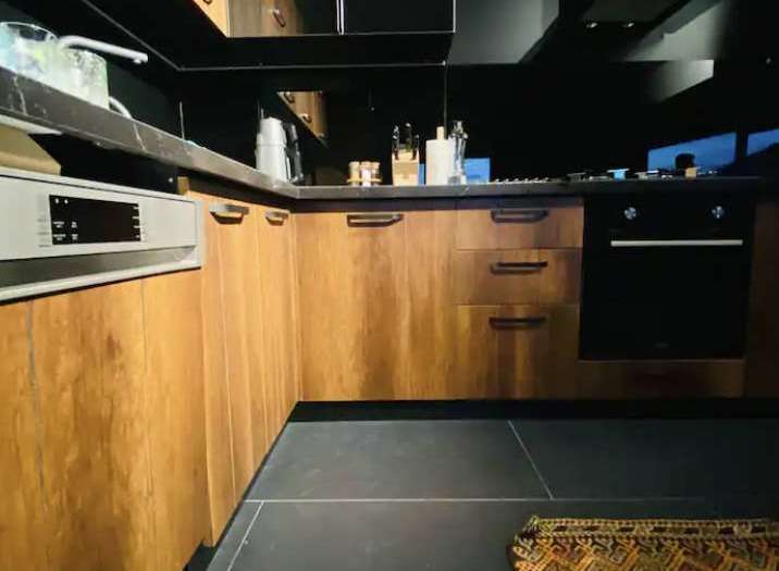 Modern kitchen design with sleek black countertops and cabinetry.