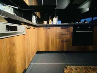 Modern kitchen design with sleek black countertops and cabinetry.