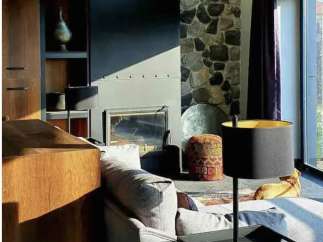 Discover the charm of this stunning property, featuring a cozy living room with a stone fireplace and a stylish sofa.