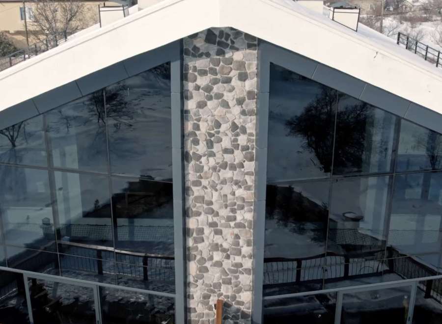 This stunning property boasts a unique architectural design with expansive glass windows, offering breathtaking views.
