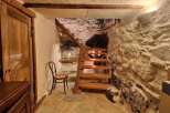 Discover the charm of this unique property, featuring a rustic wooden staircase descending into a captivating stone cellar.