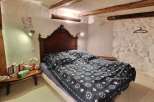 Charming bedroom with exposed wooden beams and stone walls.
