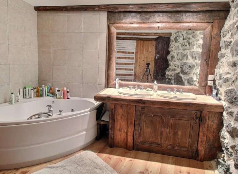 Rustic bathroom with a large corner bathtub and double vanity.