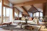 Experience luxury living in this stunning chalet-style home, boasting a bright and airy interior with exposed wooden beams and large windows.