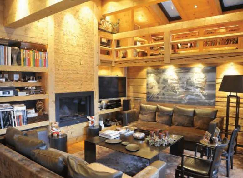 This stunning living room boasts a cozy and inviting atmosphere with its wooden interior and fireplace.
