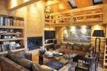 This stunning living room boasts a cozy and inviting atmosphere with its wooden interior and fireplace.