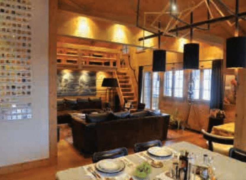 Experience rustic charm in this inviting living space, featuring a cozy seating area and a dining table set for a delightful meal.