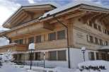 This charming wooden chalet, nestled in a snowy landscape, exudes warmth and rustic elegance.