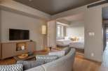 This modern hotel room boasts a spacious layout with a comfortable seating area and a large flat-screen TV.