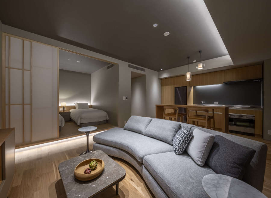 This modern apartment boasts a spacious open-plan living area with a curved sofa, perfect for relaxation.