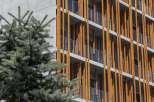 This modern apartment building boasts a unique architectural design, featuring a striking contrast between sleek concrete and warm wood accents.