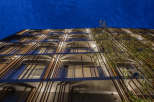 This modern apartment building features a unique architectural design with wooden slats creating a striking facade.