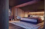 Cozy bedroom with wooden walls and a rustic rug.