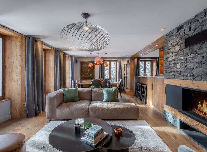 Experience luxury living in this stunning chalet, featuring a cozy fireplace and a stylish living area.