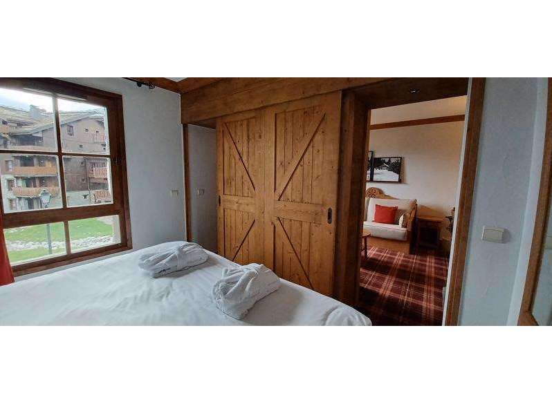 Experience rustic charm in this cozy bedroom featuring beautiful wooden sliding doors.
