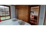 Experience rustic charm in this cozy bedroom featuring beautiful wooden sliding doors.