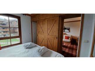 Experience rustic charm in this cozy bedroom featuring beautiful wooden sliding doors.