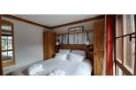 Cozy up in this charming bedroom featuring a comfortable bed and inviting ambiance.