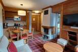 Experience cozy living in this charming apartment featuring a rustic wooden interior and a warm plaid carpet.
