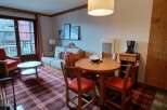 Experience cozy living in this charming apartment, featuring a comfortable sofa and a dining area perfect for meals or work.
