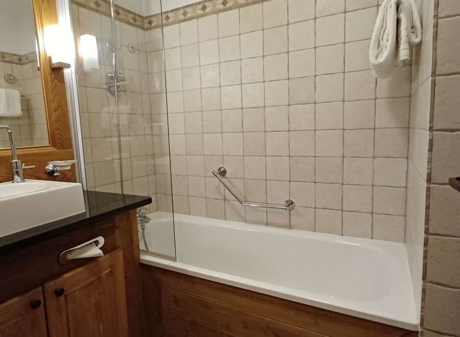 Experience comfort and style in this well-appointed bathroom, featuring a sleek vessel sink and a spacious bathtub with a glass enclosure.