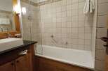 Experience comfort and style in this well-appointed bathroom, featuring a sleek vessel sink and a spacious bathtub with a glass enclosure.