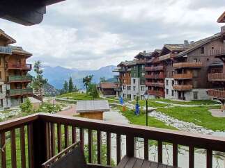 Experience mountain living in this stunning alpine village featuring charming wooden chalets with stone accents and private balconies offering breathtaking views.