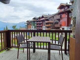 Enjoy breathtaking mountain views from this charming balcony, complete with a table and chairs for al fresco dining.