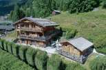 Discover a stunning wooden chalet nestled in a picturesque mountain setting.