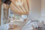 Experience luxury in this stunning bedroom with a breathtaking mountain view.