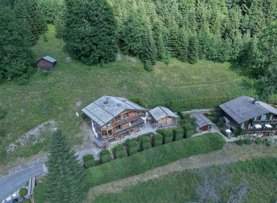 Nestled amidst lush greenery, this stunning property boasts a charming wooden chalet-style home.
