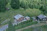 Nestled amidst lush greenery, this stunning property boasts a charming wooden chalet-style home.
