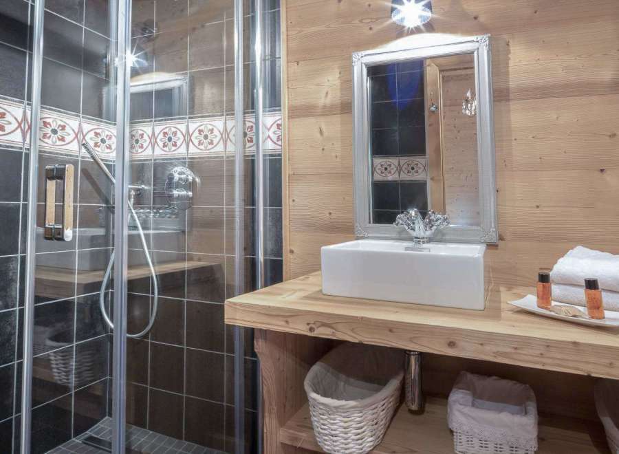 This charming bathroom features a rustic wooden vanity and a sleek, modern shower.