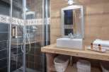 This charming bathroom features a rustic wooden vanity and a sleek, modern shower.