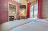 Experience the charm of this cozy bedroom, featuring a warm wooden interior and a touch of rustic elegance.